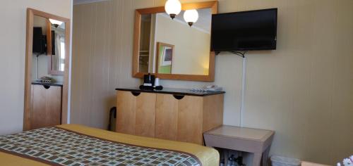 a hotel room with a bed and a mirror at Pinebrook Motel in Lake George