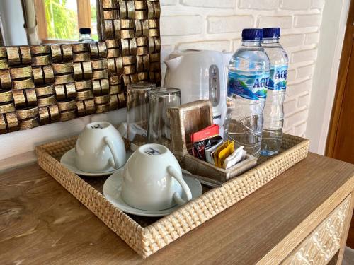 a tray with two dishes and bottles of water at Wide Sands Beach Retreat in Pulukan