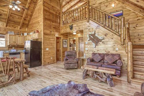 a living room of a log cabin with a staircase at Heavenly Bear, Hot Tub, FREE Attraction tickets for each paid day, Pool Table, WIFI!!! in Sevierville