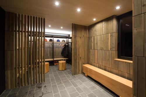a hallway with wooden walls and benches in a room at Hiyoku in Niseko