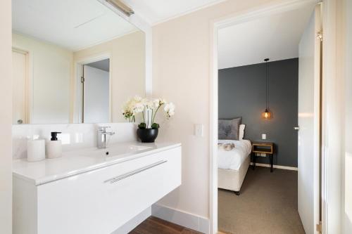 a white bathroom with a sink and a mirror at Luxury Spa Retreat with Ocean and Hinterland Views in Montville