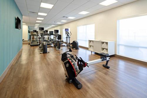 a gym with cardio equipment and a large screen at Holiday Inn Express & Suites - Murrieta by IHG in Murrieta