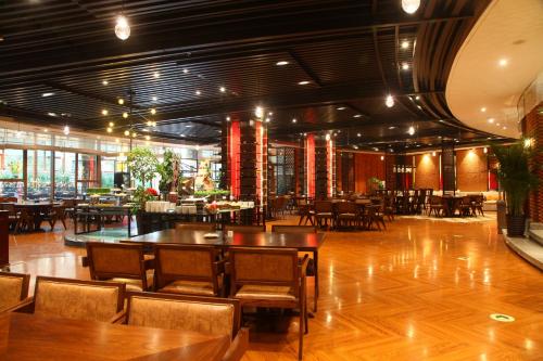 un restaurante con suelo de madera, mesas y sillas en Holiday Inn Dalian Hot Spring, an IHG Hotel en Dalian