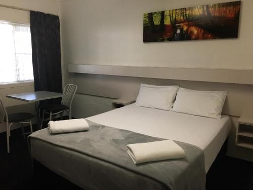 a hotel room with a bed with two towels on it at Balonne River Motor Inn in Saint George