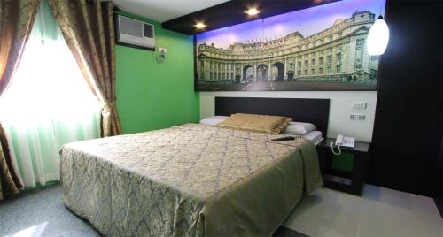 a bedroom with a bed with a picture on the wall at Eurotel Makati in Manila