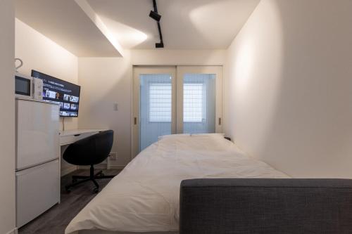 a bedroom with a bed and a desk and a window at Home Sweet Office Heiwajima in Tokyo