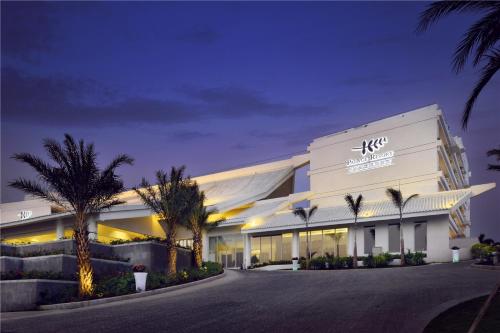 a large white building with palm trees in front of it at Palace Resort Villas Yalong Bay Sanya in Sanya