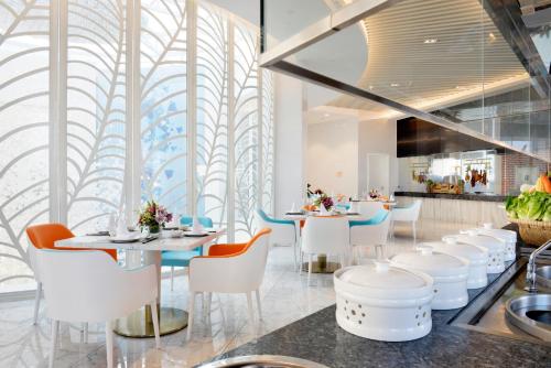 a restaurant with white tables and white chairs at Palace Resort Villas Yalong Bay Sanya in Sanya