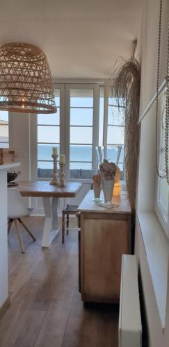 a living room with a table and a view of the ocean at Opaline Baie de somme in Ault