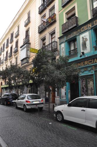 dos coches estacionados en una calle frente a los edificios en Hostal Los Arcos, en Madrid