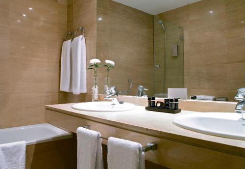 Un baño con dos lavabos y un espejo. en Boutike Cibeles, en Madrid