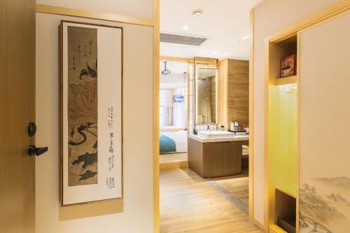 a room with a bathroom with a sink and a mirror at Days Hotel by Wyndham Binjiang Changsha in Changsha