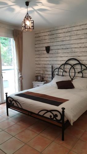 キュエールにあるLa Villa d'Olivèneの木製の壁のベッドルーム1室(大型ベッド1台付)