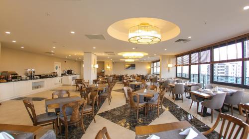 un ristorante con tavoli e sedie in legno e finestre di Ramada by Wyndham Nigde a Nigde