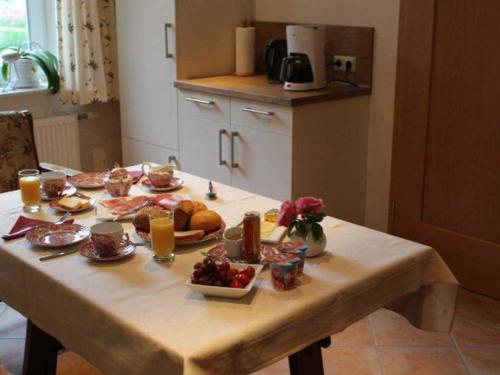 una mesa con comida y fruta encima en Gaestehaus An der Fehnroute I, 11037, en Leer