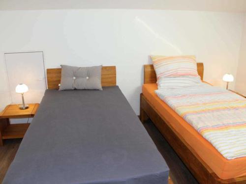 łóżko pojedyncze w pokoju z 2 lampami w obiekcie Gaestehaus An der Fehnroute II, 11041 w mieście Leer