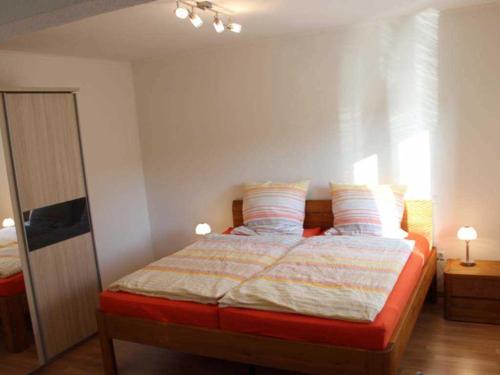 Gaestehaus An der Fehnroute II, 11041 في لير: غرفة نوم مع سرير مع وسادتين