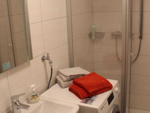 W łazience znajduje się prysznic, umywalka i ręcznik. w obiekcie Gaestehaus An der Fehnroute II, 11041 w mieście Leer