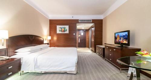 a hotel room with a bed and a flat screen tv at Millennium Harbourview Hotel Xiamen-Near Metro Station & Zhongshan Road in Xiamen