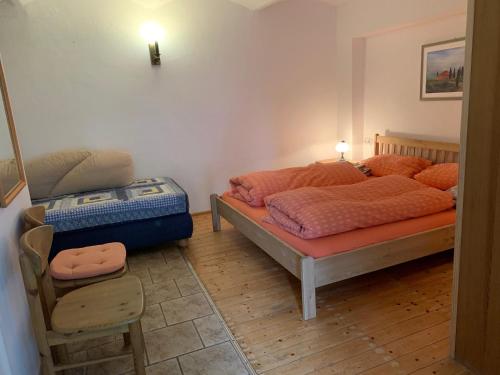 Un dormitorio con 2 camas y una silla. en Ferienwohnungen im Landhaus Wiesenbad, en Thermalbad Wiesenbad
