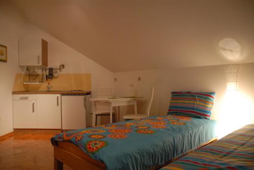 a small bedroom with a bed and a kitchen at Oriana Studios in Bled