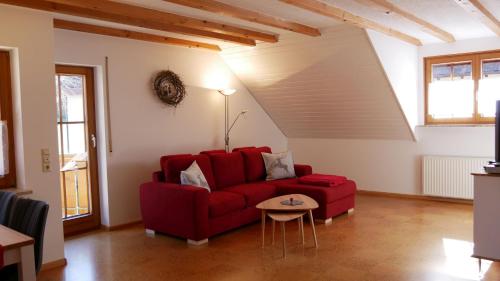 a living room with a red couch and a table at Haus Johanna in Glottertal