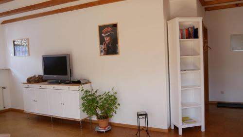 a living room with a tv on a white wall at Haus Johanna in Glottertal