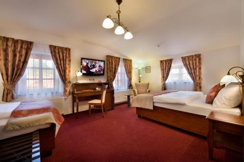 a hotel room with two beds and a desk at Hotel Joseph 1699 in Třebíč