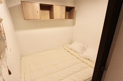 een kleine kamer met een bed en een kast bij La Ruinée Appartement chaleureux à proximité des pistes et commodités in Briançon