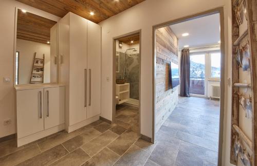 a hallway with a tile floor and a bathroom at Apartment Center in Saalbach Hinterglemm