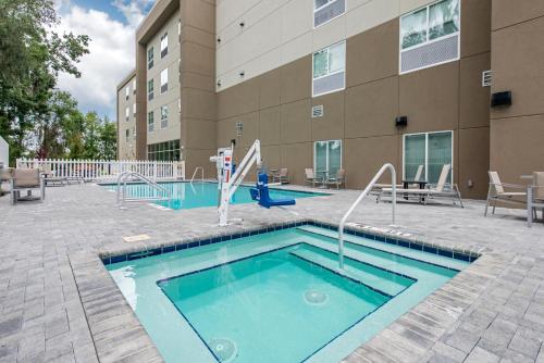 une piscine avec toboggan en face d'un bâtiment dans l'établissement Holiday Inn Express & Suites Alachua - Gainesville Area, an IHG Hotel, à Alachua
