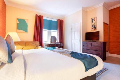a bedroom with a large bed and a television at Yardley Manor Hotel in Torquay