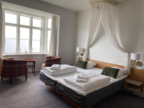 a hotel room with a bed and a window at Løgstør Badehotel - Hotel du Nord in Løgstør