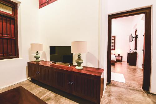 a living room with a television on a dresser at Thambu Illam in Jaffna