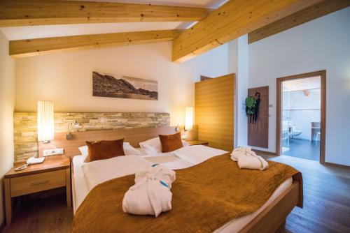 a bedroom with two beds with towels on them at Familienhotel Huber in Valles