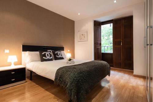 Un dormitorio con una cama grande y una ventana en Apartamentos Day Madrid SAN ANTONIO Centro Gran Via Sol Malasaña, en Madrid
