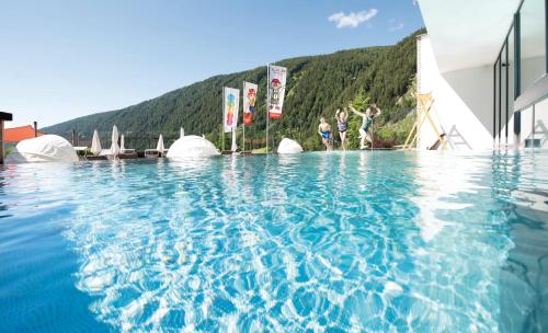 a group of people standing in a swimming pool at Familienhotel Huber in Valles