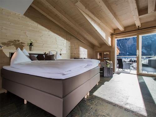 ein großes Bett in einem Zimmer mit einem großen Fenster in der Unterkunft Hotel Silberhorn in Lauterbrunnen