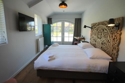 a bedroom with two beds and a window at Strandhotel Dennenbos in Oostkapelle