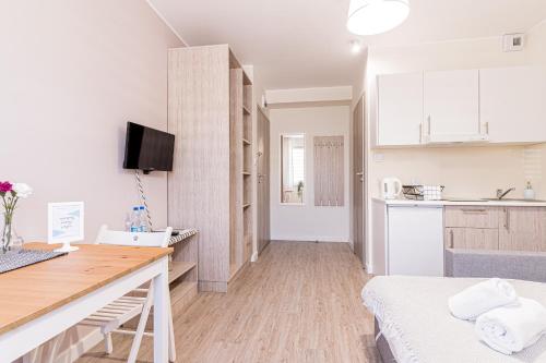 a kitchen with white cabinets and a table in a room at Apartamenty Novomiejska 17 in Lublin