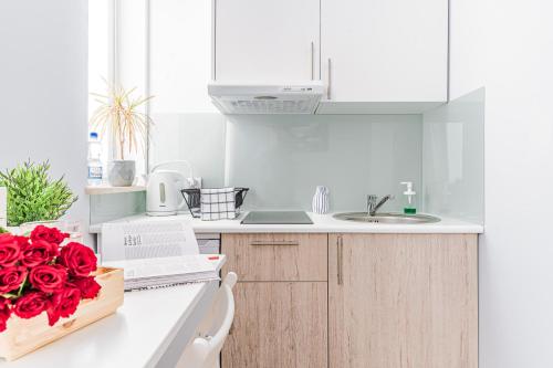 a white kitchen with a box of roses on the counter at Apartamenty Novomiejska 17 in Lublin