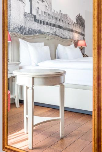 a bedroom with a bed and a table in a mirror at Boutique & Business Hotel La Tureta in Bellinzona