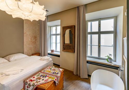 1 dormitorio con cama y lámpara de araña en Mostecka Apartment, en Praga