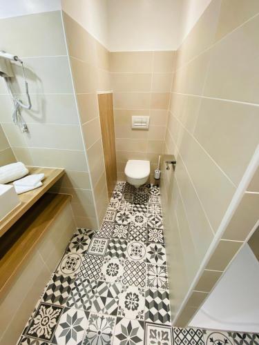 a bathroom with a toilet and a tiled floor at Sarlat.Catalina in Sarlat-la-Canéda