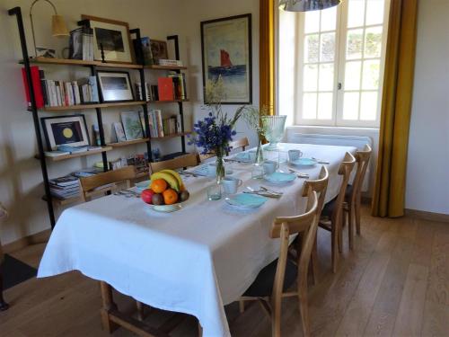 een tafel met een witte tafeldoek en een fruitschaal bij les jardins de la Matz in Plouër-sur-Rance