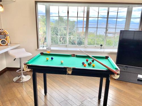 a living room with a pool table and a tv at GANADAN Cottage in Kagoshima