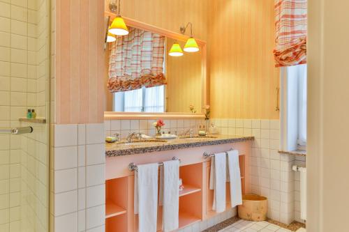 ein Badezimmer mit einem Waschbecken, einem Spiegel und Handtüchern in der Unterkunft Hotel Stadt Hamburg in Westerland