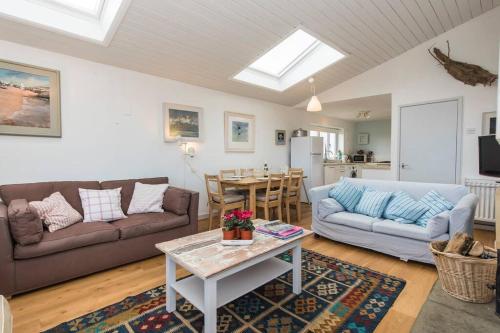 a living room with a couch and a table at TARIAN HAF-3 BED-SEA VIEW BUNGALOW-TREARDDUR BAY in Trearddur