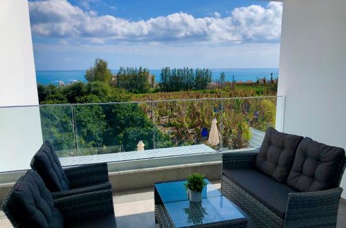 a living room with two chairs and a large window at Sophia's Seaview Luxury Villas in Paphos City