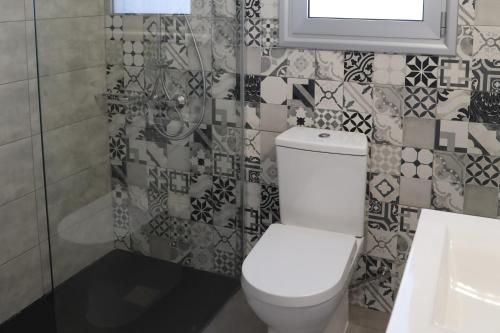 a bathroom with a white toilet and a window at Sophia's Seaview Luxury Villas in Paphos